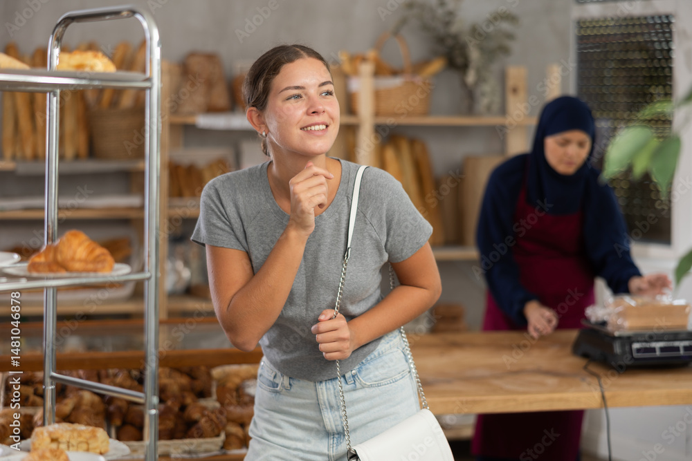 Female customer choosing bread and other delicious pastries in the oriental bakery