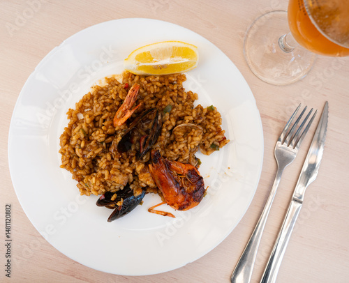 Obraz na płótnie Paella made of rice and different seafood served in plate with other table appointments w salonie