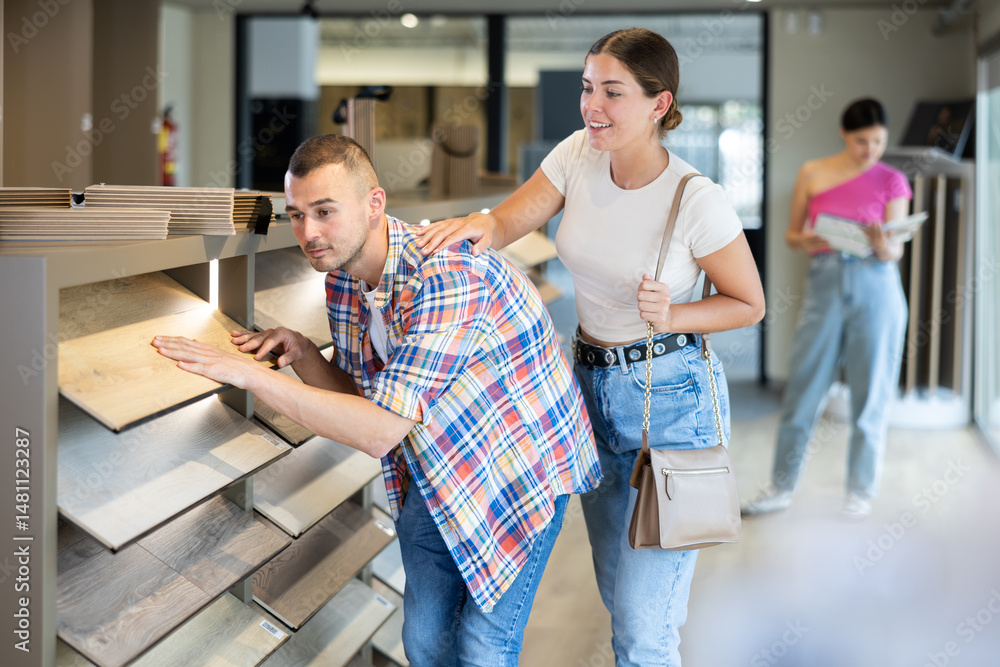 Young married couple chooses laminate flooring together in a hardware store