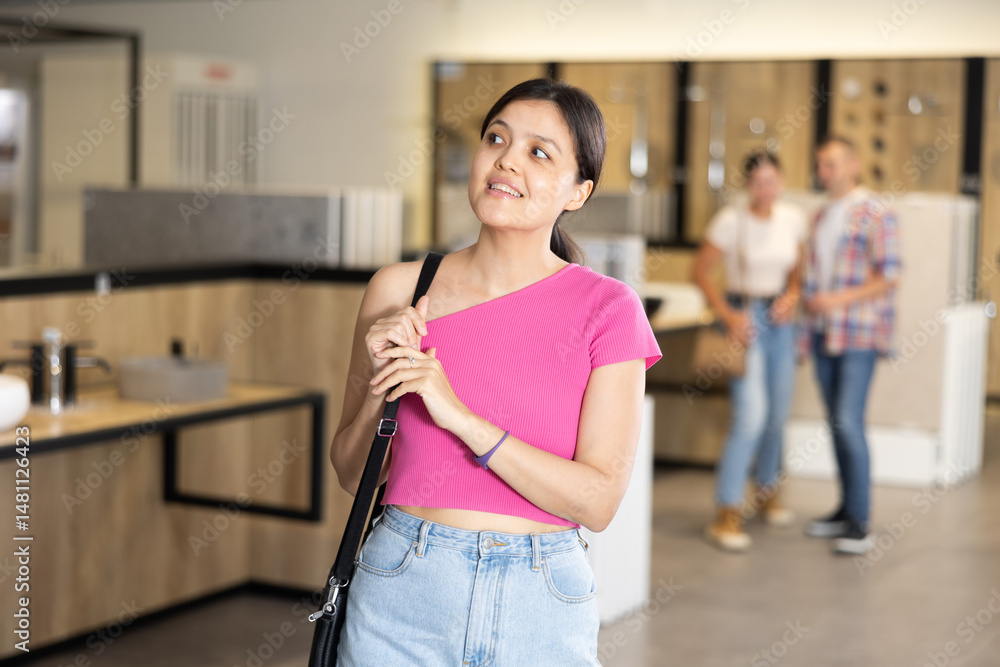 Young female shopper looking around in bathroom department of hardware store