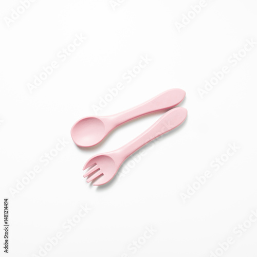 Baby feeding spoon and fork in soft pink. Ideal for baby gear, infant nutrition content, or early childhood care themes.