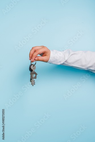 Businessman or real estate agent holding house key for his client after signing contract in office concept for real estate Moving house or renting property