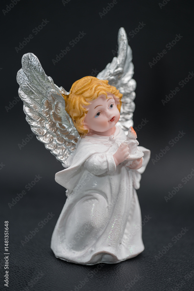 Fototapeta premium white angel trinket on a black background