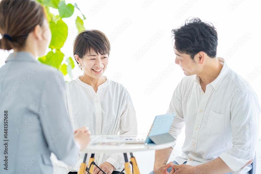 Obraz premium スーツ姿の女性からインテリアの説明を受ける夫婦