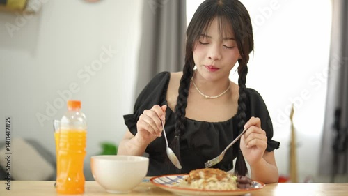 Wallpaper Mural Young woman enjoying a homemade meal while sitting at a cozy table, showing delight as she savors every bite, surrounded by bright, warm colors and kitchen decor Torontodigital.ca