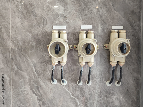 Three Stylish Plumbing Valves on a Decorative Marble Wall for Modern Interiors