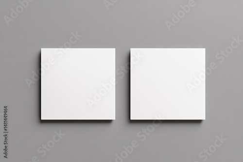 Two blank square cards laid flat on a neutral gray surface.  Each card is white and presents an empty template for design