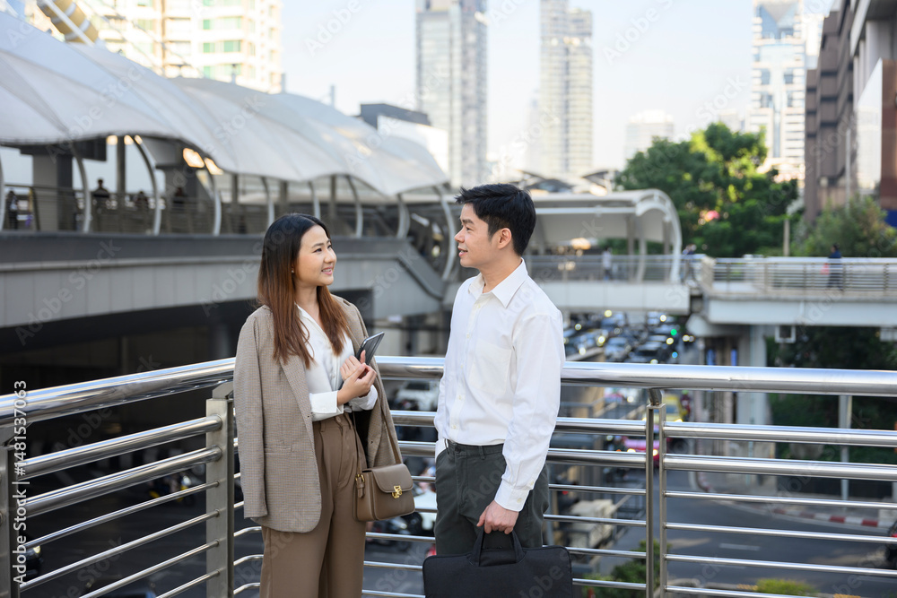 Obraz premium Businesspeople discussing work on footbridge in urban setting