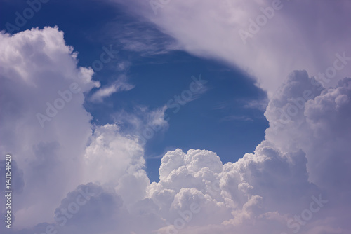 Dynamic sky with textured cumulus clouds and blue patches, creating a vibrant atmospheric background.

