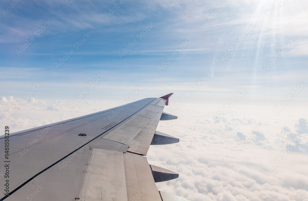 Obraz premium View from the airplane window at a beautiful cloudy sky and the airplane wing