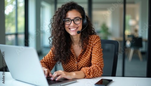 Portrait of Latin American business woman, office worker looking at camera and smiling, using headset and laptop for remote online communication, customer support tech call center worker.