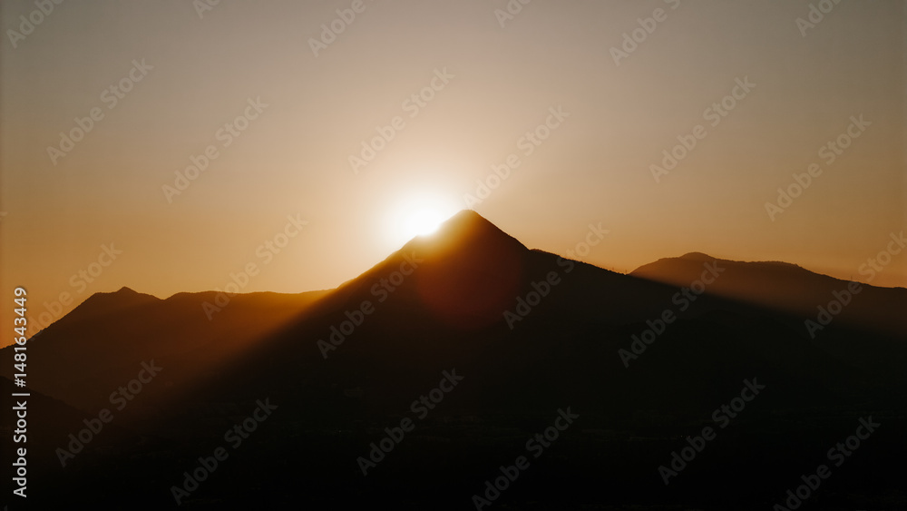 Mountains Silhouette during an orange sunset behind the summit Mountains Silhouette during an orange sunset behind the summit
