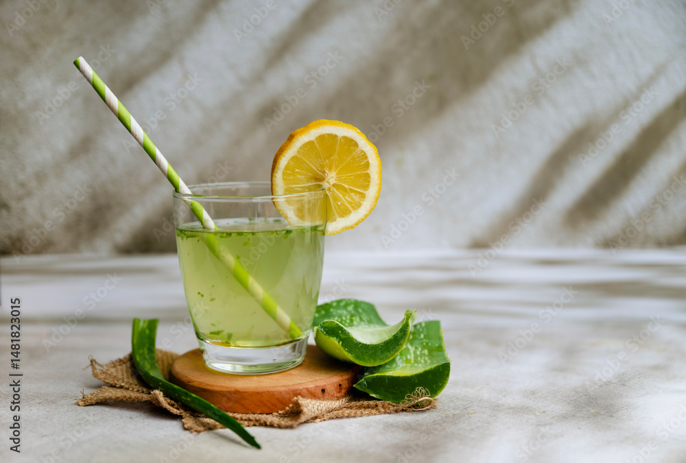 Fototapeta premium Fresh aloe vera drink in glass cup with aloe slices 