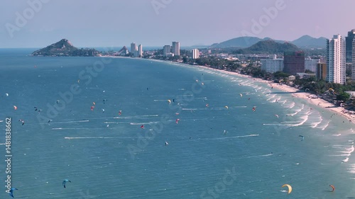 Beach crowded with kitesurfers. High kiteboarding and windy season in Thailand