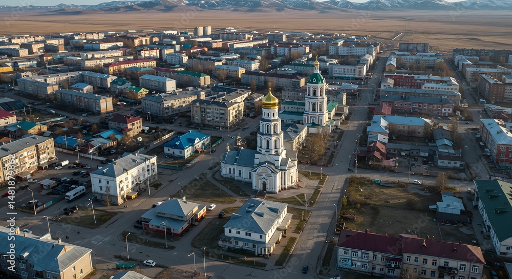 Obraz premium Aerial View of a Cityscape with Church and Distant Mountains