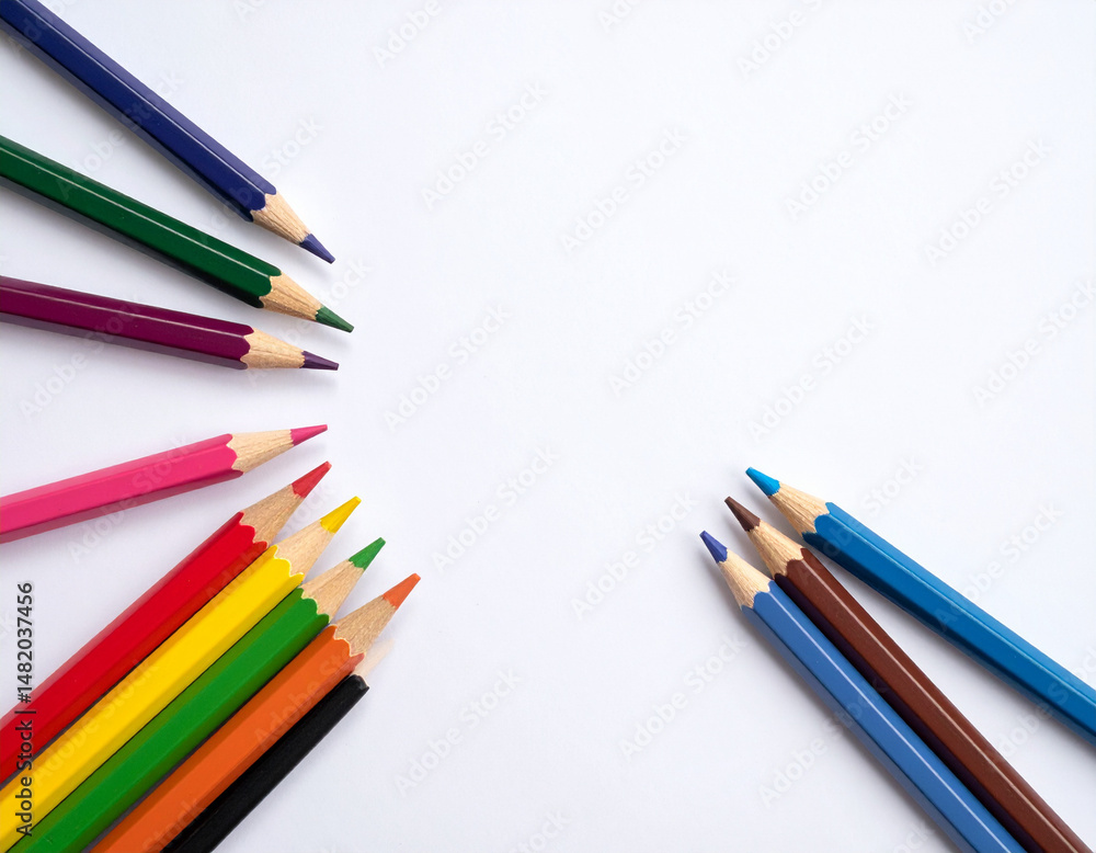 Naklejka premium A set of colored pencils arranged in a circular pattern on a blank white surface.