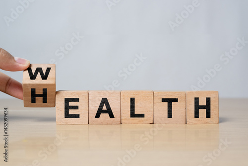 Hand flipping wooden cube from “Wealth” to “Health” on a table. Concept of life balance, insurance investment, and prioritizing healthcare over finances