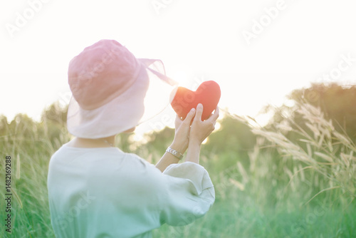 Woman holding red heart in hands, closeup.