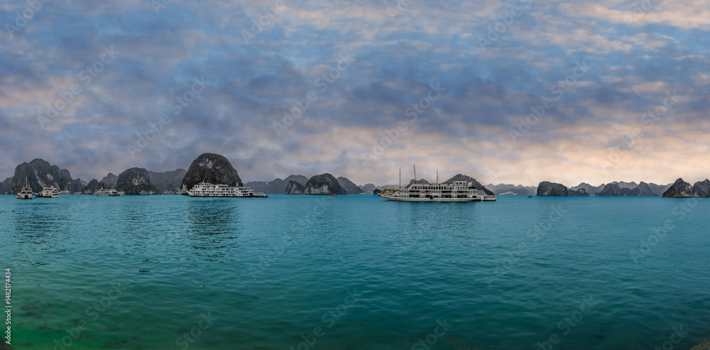 Fototapeta premium Halong Ha Long Bay Hanoi this Vietnamese wonder is littered with mountains and Rock cliffs popping out of the ocean, lush green mountains in Vietnam