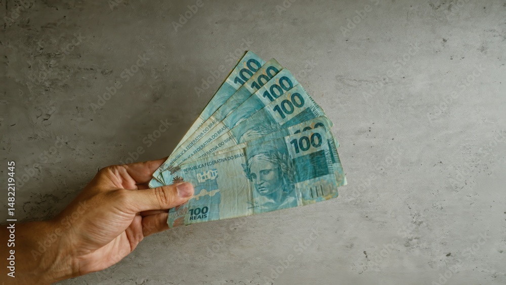 custom made wallpaper toronto digitalHand holding multiple brazilian 100 reais on a concrete background, showcasing currency in brazil