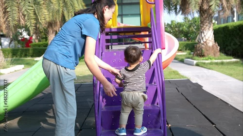 While in vacation at home, a mother engages in activities with little kid in the park