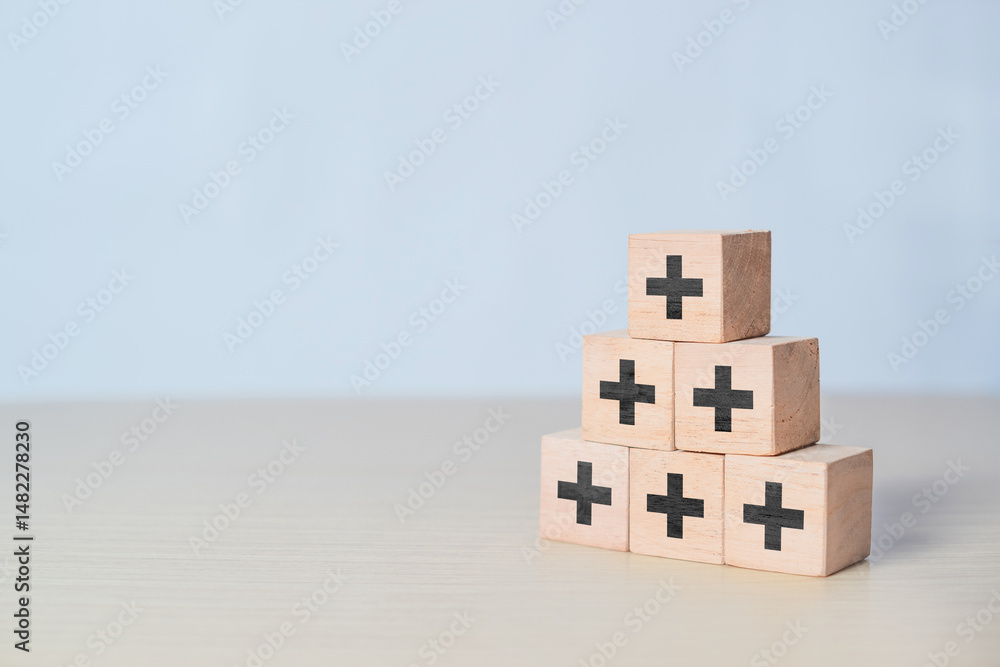 Fototapeta premium Plus sign in wooden cube block stacking. Addition and positive mindset thinking such as profit, benefits, development, CSR represented, motivation, increase concept and copy space