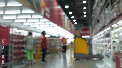 Defocused Blurred view of store worker safety work with folklift truck at warehouse hypermarket superstore store background.
