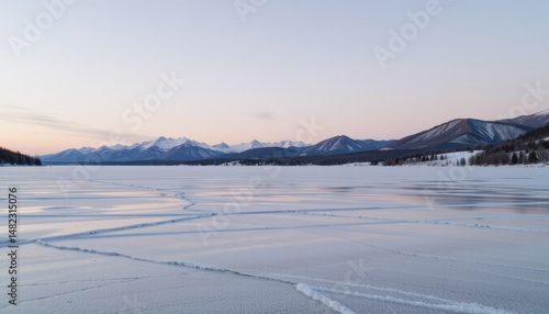 Frozen lake with mountains under a pastel sky.