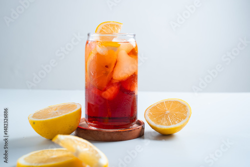 Iced tea with lemon and ice in a tall glass on a white background. The concept of a refreshing drink or lemonade on a hot summer day. Front view and copy space.