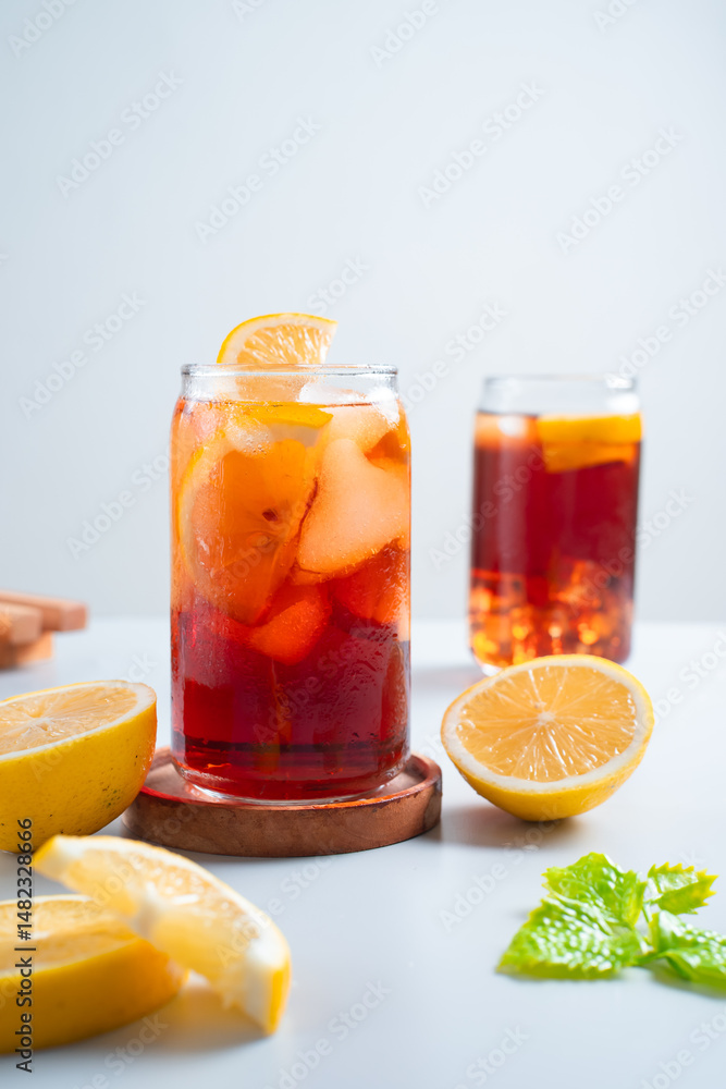Iced tea with lemon and ice in a tall glass on a white background. The concept of a refreshing drink or lemonade on a hot summer day. Front view and copy space. Iced tea with lemon and ice in a tall glass on a white background. The concept of a refreshing drink or lemonade on a hot summer day. Front view and copy space.