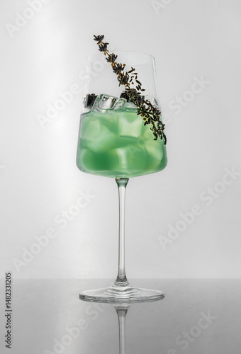 Studio photo of green cocktail with herbs and ice