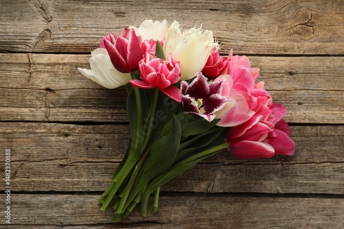 Beautiful tulips on wooden background, top view