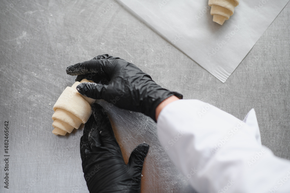 Fototapeta premium Baker making croissant dough in bakery kitchen