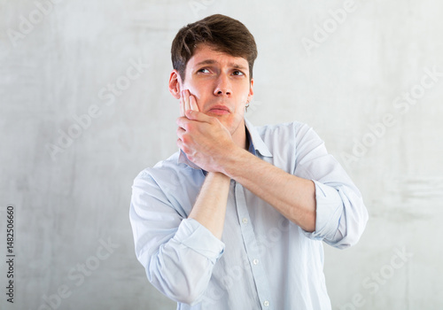 Unhappy man having a toothache in living room