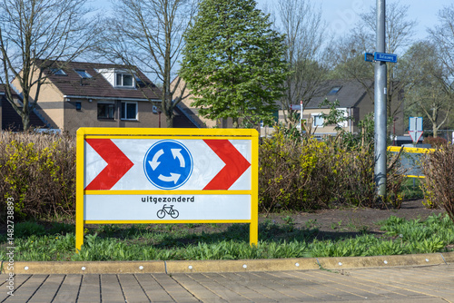 Foto Roundabout sign in Utrecht, Netherlands, with uitgezonderd (except) and a bicycle symbol, indicating an exception for cyclists