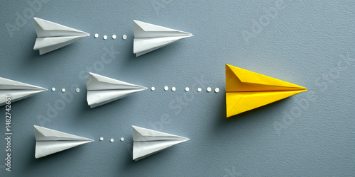 Several white paper airplanes follow a path, with a single yellow airplane leading the way, symbolizing innovation, leadership, and breaking from the norm