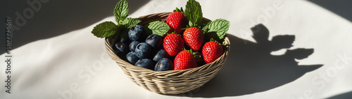 A Collection of Fresh Berries Artistically Arranged in a Decorative Basket on Light Background
