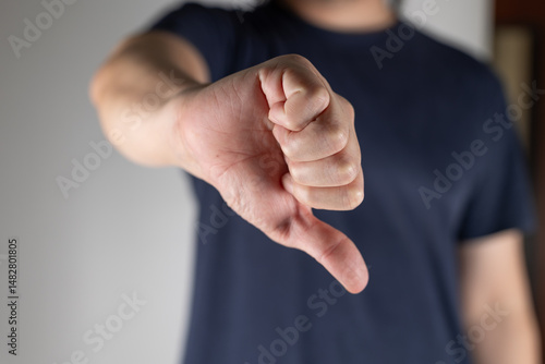 Wallpaper Mural A man makes a thumbs down gesture. A man makes a displeased gesture by pointing his thumb down. Torontodigital.ca
