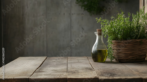 Rustic wooden table with glass bottle of olive oil and wicker basket filled with fresh green herbs, creating natural and cozy kitchen atmosphere