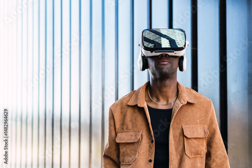 Man wearing virtual reality headset, exploring digital world amid contemporary cityscape