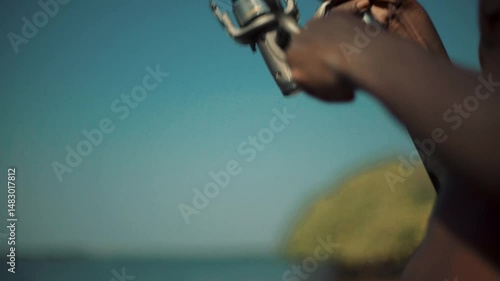 fisherman's hands battling big catch: close-up of reeling rod, artistic motion blur, shallow depth of field, intense struggle on fishing line