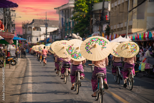 Bild auf Leinwand Women holding beautiful umbrellas and cycling