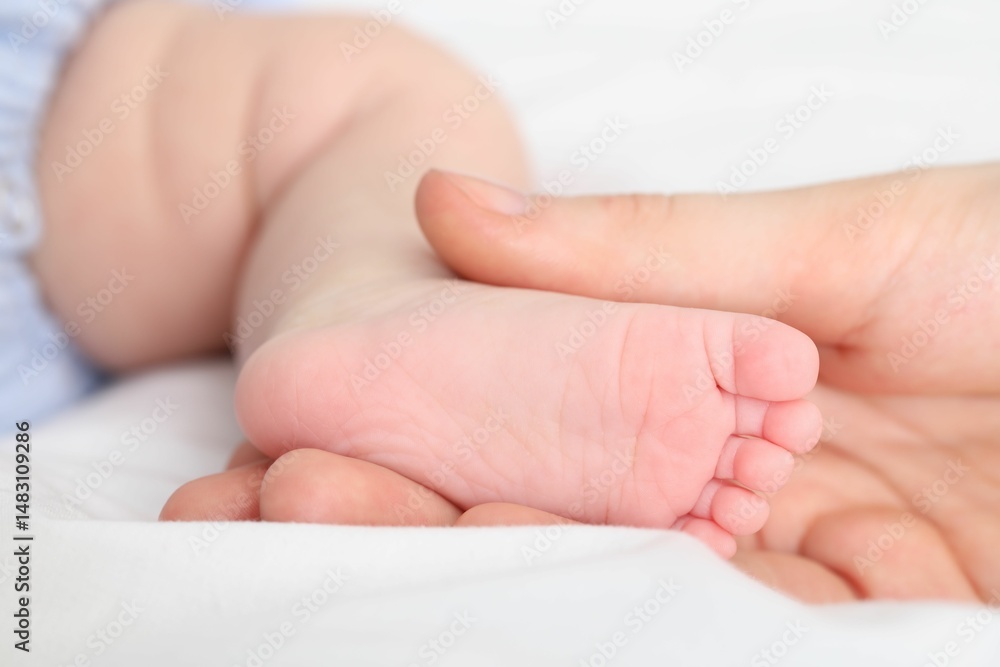Mother with her little baby on bed indoors, closeup Mother with her little baby on bed indoors, closeup