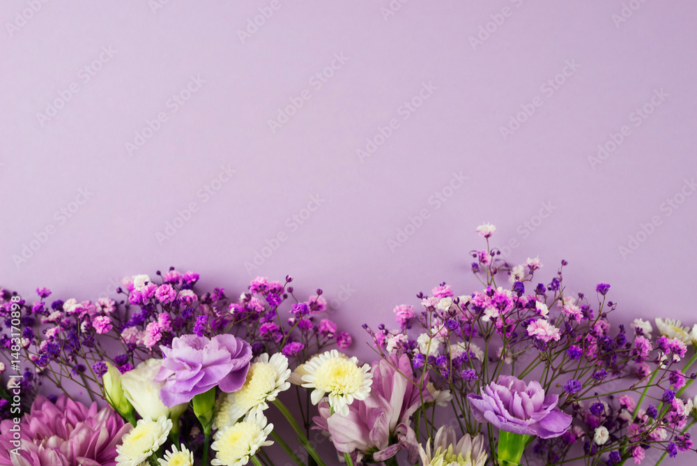 Naklejka premium Creative layout of purple flowers composition on purple background. Flat lay with copy space.