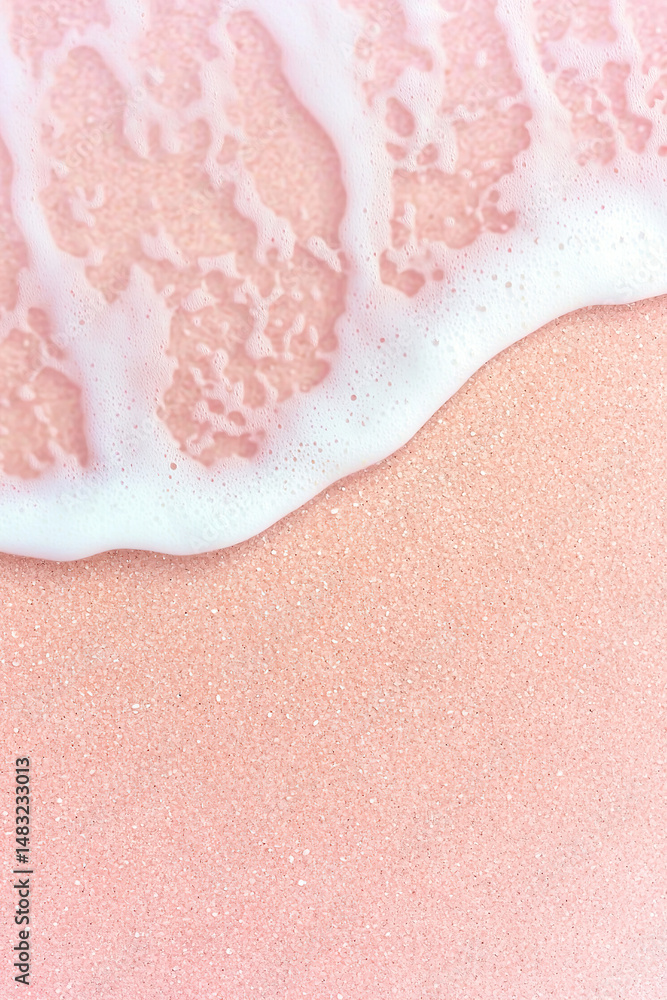 Fototapeta premium Soft pink sand beach with gentle white sea foam creating serene and calming coastal scene