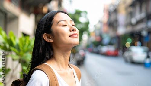 Mujer con los ojos cerrados respirando aire puro en una ciudad limpia y sin contaminación que simboliza libertad, conexión con la vida, y búsqueda de equilibrio, calma y conciencia en la modernidad