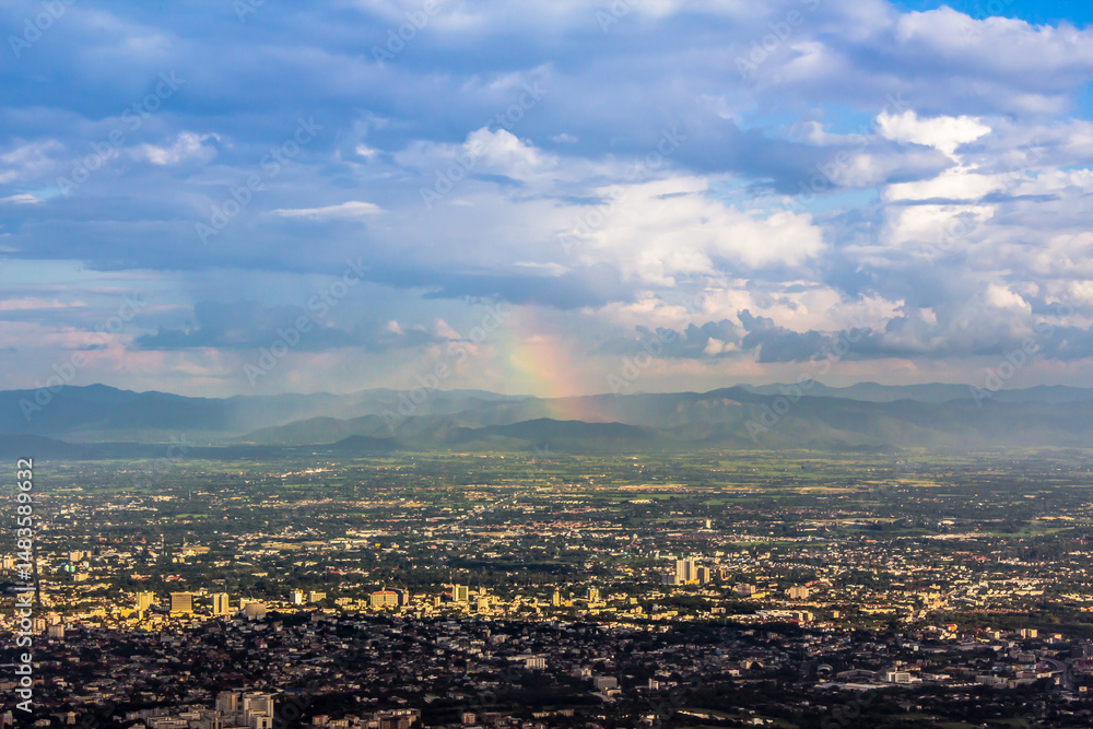 Obraz premium High angle view of Chiang Mai, Thailand with mountains and rainbow sky as a daytime backdrop.