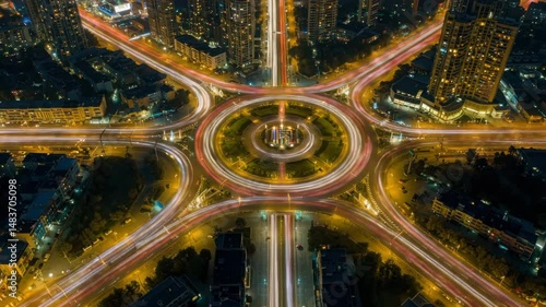 Urban Symphony: An aerial view of a dynamic cityscape at twilight, where roads converge in a circular design, tracing intricate patterns of light and movement.
