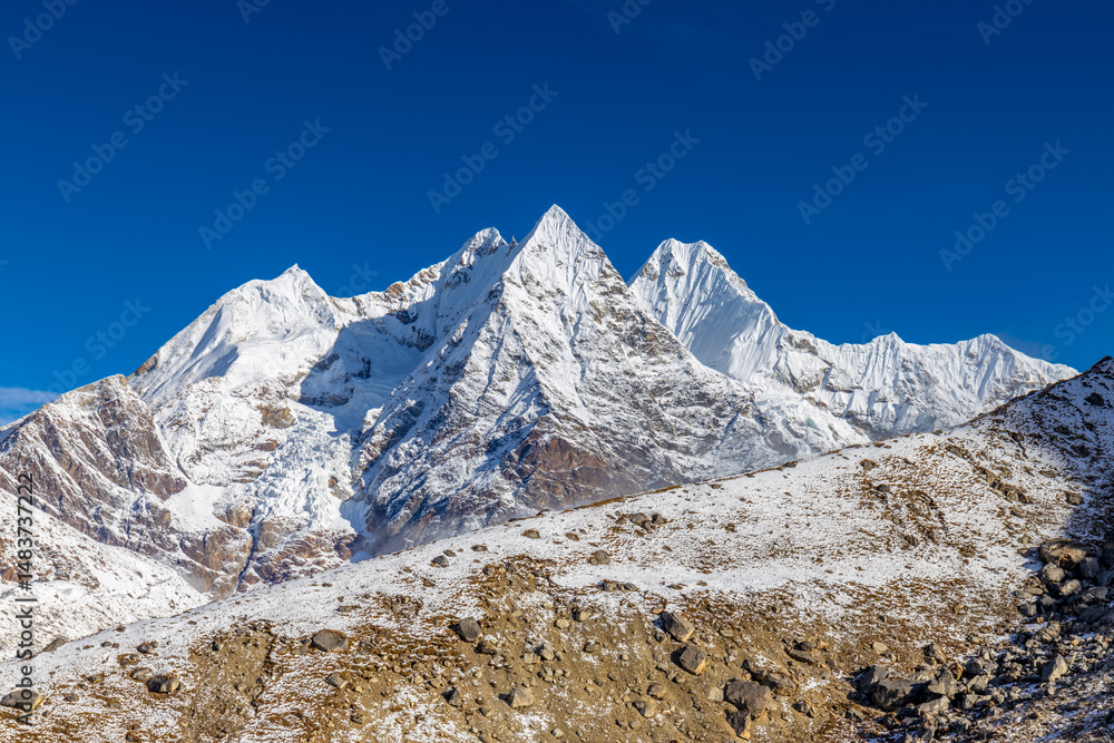 Obraz premium Mera Peak high altitude mountain summit ascent in Himalayas. Stunning views above the clouds at sunrise from the top of the mountain. Alpine route climbing on the snow path in Himalayas