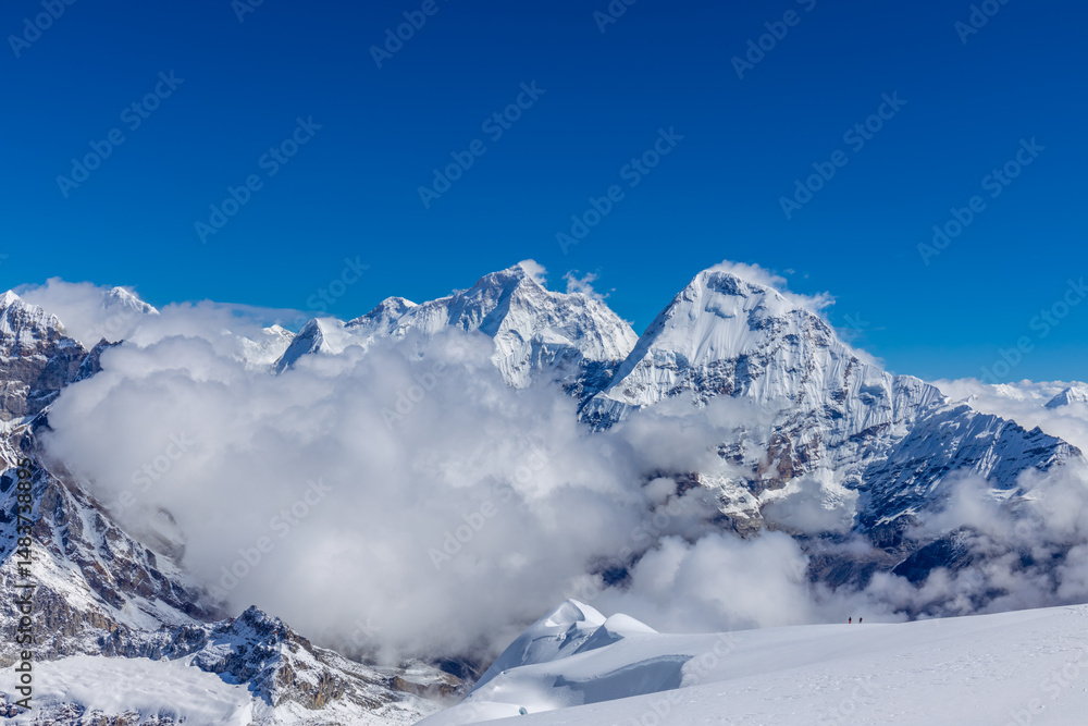 Obraz premium Mera Peak high altitude mountain summit ascent in Himalayas. Stunning views above the clouds at sunrise from the top of the mountain. Alpine route climbing on the snow path in Himalayas